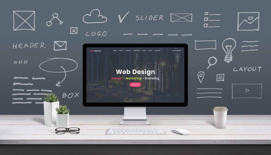 Modern computer screen displaying web design services with creative workspace background.