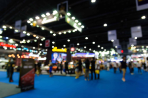 Modern trade show exhibition booth with lighting and visitors at a busy event. Trade show booth with lighting and visitors at a busy event.